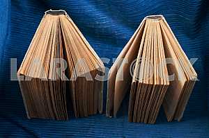 Открытая книга, стопка книг в твердом переплете на деревянном столе. Обратно в школу. Копирование пространства