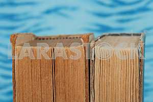 Old and used hardback books or text books on wooden table. Books and reading are essential for self improvement, gaining knowledge and success in our careers, business and personal lives. Copy space