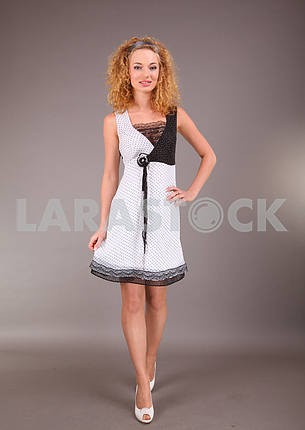 Beautiful young woman in light dress with gray background
