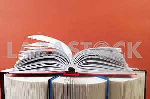 Открытая книга, стопка книг в твердом переплете на деревянном столе. Обратно в школу. Копирование пространства