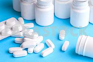 Many pills and tablets isolated on light blue background