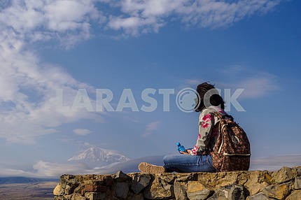 Man sitting on rocks and looking at Mount Ararat.