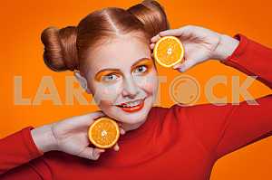 Young beautiful fashion model with orange. studio shot.