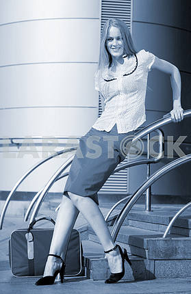 Young woman, blond, against the backdrop of the station. In all 