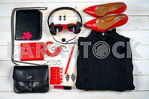 Women clothing set and accessories on white wooden background.
