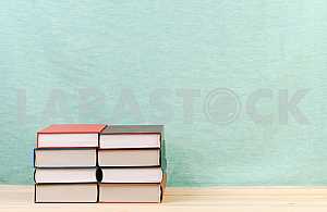 Открытая книга, стопка книг в твердом переплете на деревянном столе. Обратно в школу. Копирование пространства