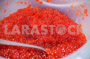 Bucket with red caviar close-up.