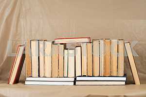 Old and used hardback books or text books on wooden table. Books and reading are essential for self improvement, gaining knowledge and success in our careers, business and personal lives. Copy space