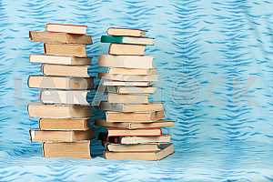 Old and used hardback books or text books on wooden table. Books and reading are essential for self improvement, gaining knowledge and success in our careers, business and personal lives. Copy space