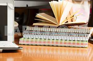 Stack of hardback books on wooden table. Back to school. Copy space. Top view