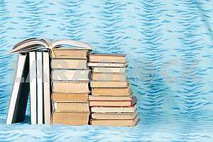 Old and used hardback books or text books on wooden table. Books and reading are essential for self improvement, gaining knowledge and success in our careers, business and personal lives. Copy space