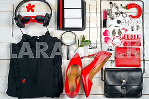 Women clothing set and accessories on white wooden background.