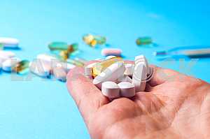 Many pills and tablets isolated on light blue background