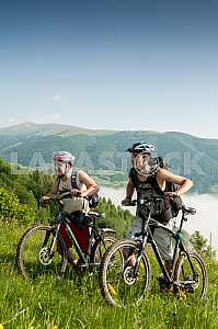 Tourists with backpacks on the bike in the Carpathian Mountains