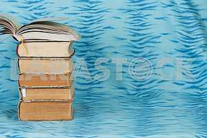 Old and used hardback books or text books on wooden table. Books and reading are essential for self improvement, gaining knowledge and success in our careers, business and personal lives. Copy space