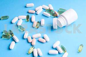 Many pills and tablets isolated on light blue background