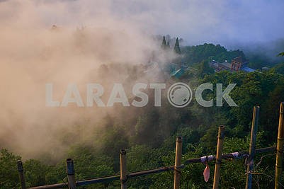 Foggy sunrise on top of mountain over the ancient asian building