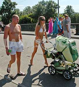 Young parents are walking on a bridge in Venice Hydropark Kiev