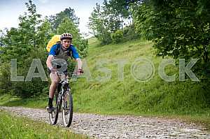 Tourists with backpacks on the bike in the Carpathian Mountains