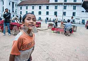 The boy looks curiously at the tourists