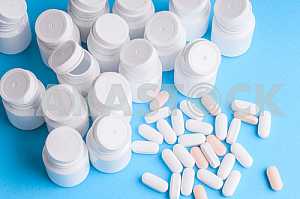 Many pills and tablets isolated on light blue background