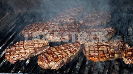 стейк из говядины приготовления пищи на открытом гриле пламени
