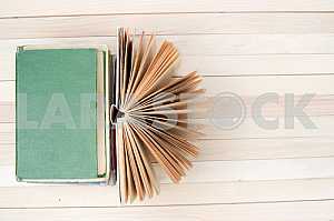 Stack of hardback books on blue cloth. Back to school. Copy space