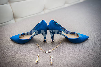 Beautiful bride shoes with a gorgeous earrings on the sofa girl in shoes with high heels pair of blue shoes with heels shoes with the necklace