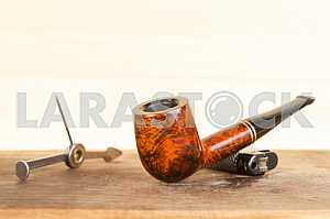 Smoking pipe on a wooden table. Aroma. Copy space