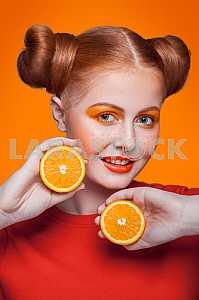 Young beautiful fashion model with orange. studio shot.