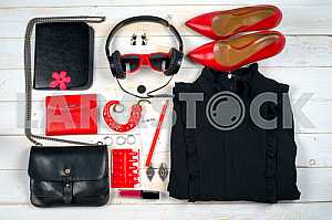 Women clothing set and accessories on white wooden background.