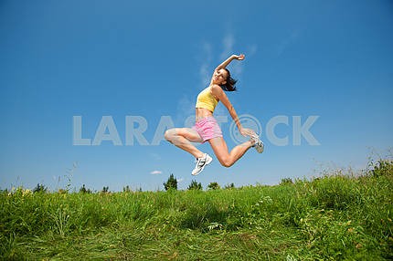 Young athletic girl jumping on grass