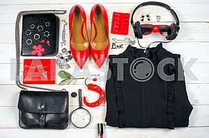 Women clothing set and accessories on white wooden background.