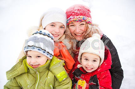 Портрет счастливой матери и детей вместе в снегу на холодный