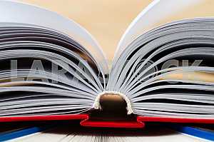 Открытая книга, стопка книг в твердом переплете на деревянном столе. Обратно в школу. Копирование пространства
