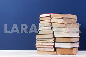 Stack of hardback books on wooden table. Back to school. Copy space