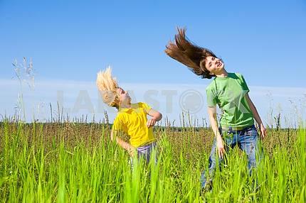 Happy mother and daughter making exercises on field.