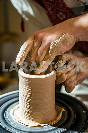 Potter makes a jug on a potter's wheel