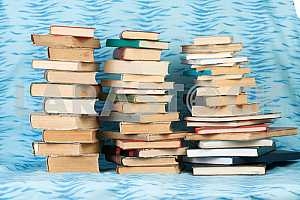 Old and used hardback books or text books on wooden table. Books and reading are essential for self improvement, gaining knowledge and success in our careers, business and personal lives. Copy space