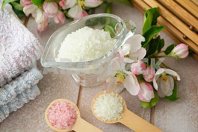 White bath salt with sakura, pink and white salt on wooden spoon, spa concept