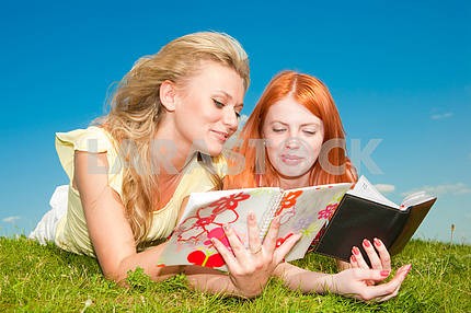 Две красивые девушки с ноутбуками на открытом воздухе . Положите на зеленой гр