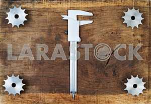 Different construction tools on a wooden background - screwdriver, caliper.