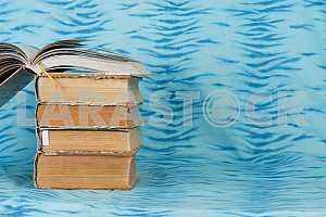 Old and used hardback books or text books on wooden table. Books and reading are essential for self improvement, gaining knowledge and success in our careers, business and personal lives. Copy space