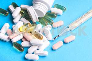 Many pills and tablets isolated on light blue background