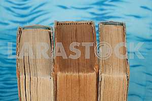 Old and used hardback books or text books on wooden table. Books and reading are essential for self improvement, gaining knowledge and success in our careers, business and personal lives. Copy space