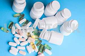 Many pills and tablets isolated on light blue background