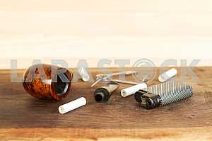 Smoking pipe on a wooden table. Aroma. Copy space