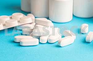Many pills and tablets isolated on light blue background