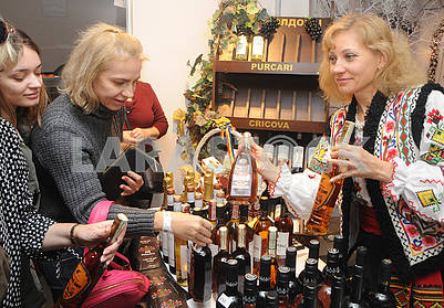Участница  ярмарки демонстрирует посетителям  молдавские вина