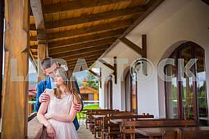 The bride groom gently hugged for a walk at the wooden terrace. dreaming bride - the groom telling words of love on her ear